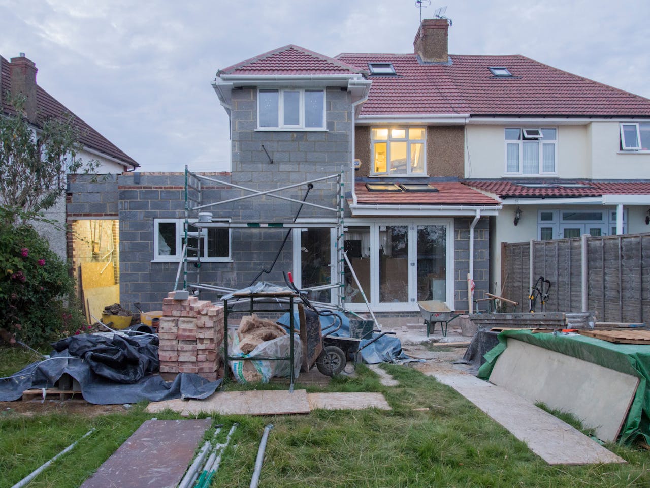 gallery-02 A suburban house undergoing major renovations with scaffolding and building materials.