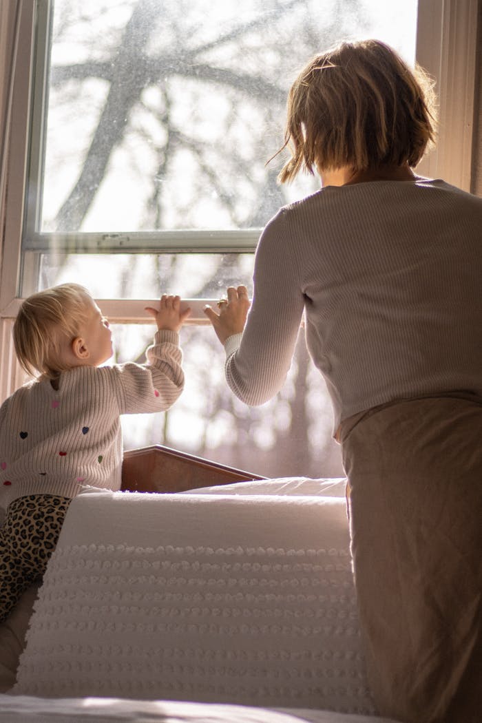 gallery-04 A mother and child enjoy the sunlight through a modern window, highlighting a cozy home setting.